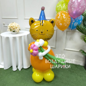 Фигура из шаров тигренок в колпаке с букетом ромашек